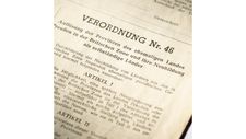 In einer hüfthohen Vitrine vor Ihnen sind 2 vergilbte, mit Text bedruckte Papierbögen aufgestellt. Der Text ist jeweils in zwei Spalten aufgeteilt, links in englischer und rechts in deutscher Sprache. Es handelt sich um die Verordnungen Nr. 46 und 47, die Gründungsdokumente von Nordrhein-Westfalen aus dem Jahr 1946.